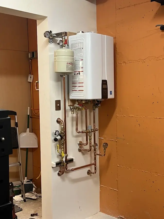Plumbing technician inspecting water heater connections in Jasper